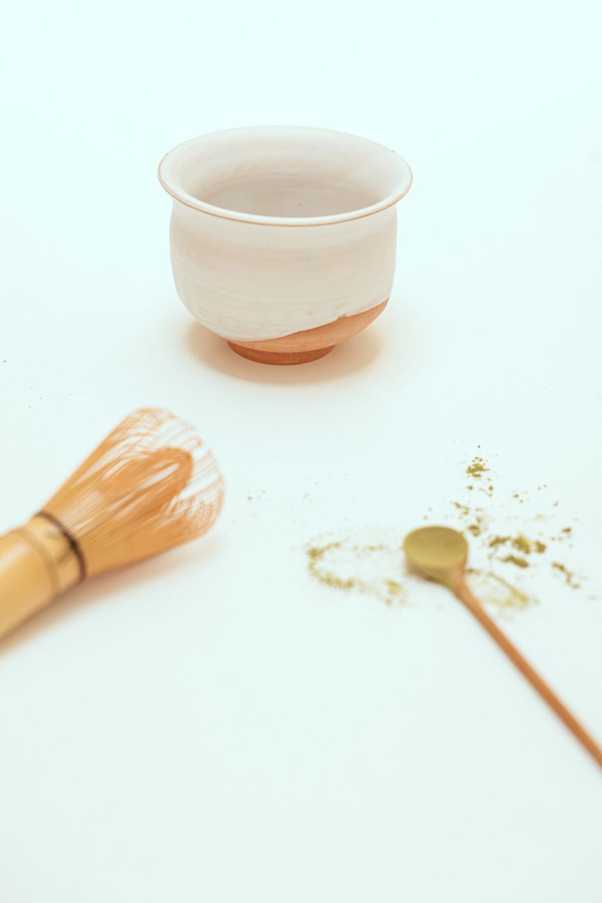 Ceremonial matcha bowl and bamboo whisk on tatami mat
